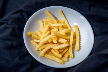 French fries in a plate French fries in a plate. on a dark background .