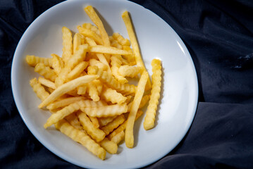 French fries in a plate French fries in a plate. on a dark background .