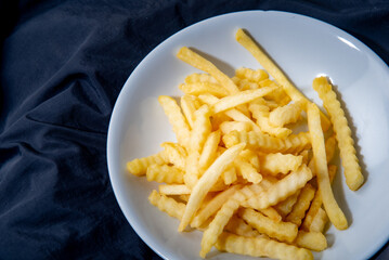 French fries in a plate French fries in a plate. on a dark background .