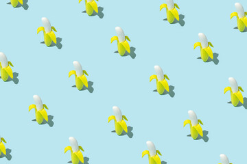 Trendy sunlight summer pattern made with banana on bright light blue background. Minimal tropical food concept.
