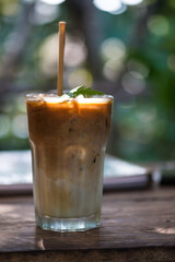 Iced coffee in a tall glass with paper straw