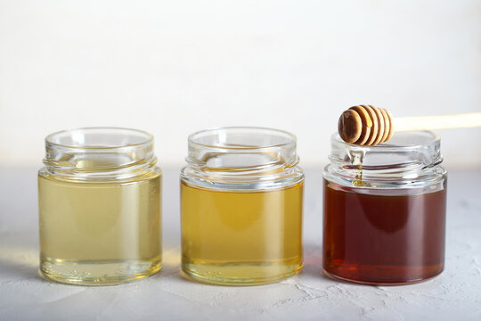 honey of different varieties is on the table in glass jars