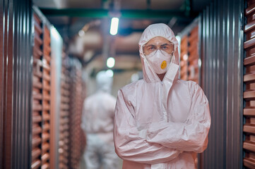 Workers in the protective gear inspecting working in the storehouse