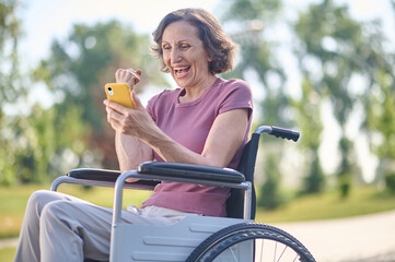 A woman on wheel-chair looking excited and feeling happy