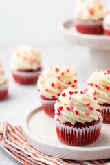 Red velvet cupcake with cream cheese frosting and red hearts sprinkles on the top. Valentine's Day concept. Selective focus.