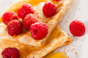 delicious pancakes with fresh raspberries and honey
