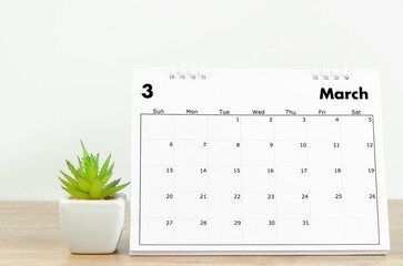 March 2022 desk calendar on wooden background.