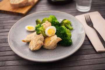 healthy appetizer of chicken pieces with broccoli and quail eggs in bowl for healthy lunch