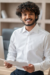 Young indian man in a white shirt in the office