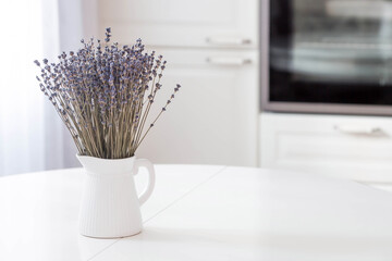 Provence. A beautiful bouquet of lavender in a white ceramic jug on the table. In the background is...