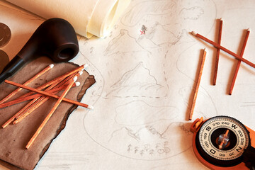 Flatlay image of treasures map with smoking pipe, matches, compass. Travel and adventures...