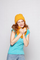 red-haired girl in a warm hat on a light background