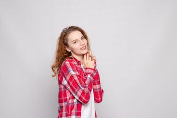 red-haired young girl in a plaid shirt on a white background with a place for text