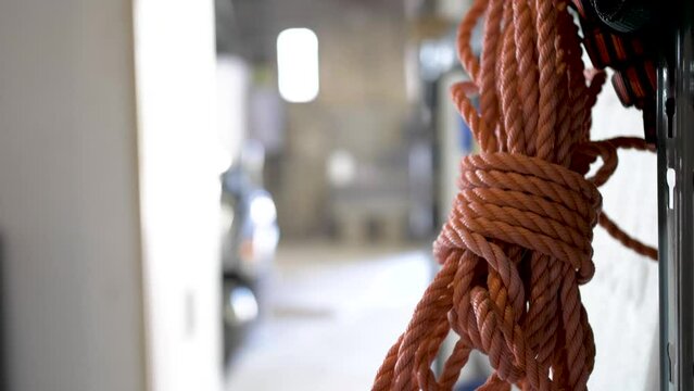 Red security nylon rope tied in a bundle at a warehouse, Close up pan left shot