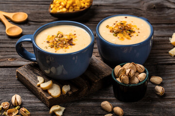 Corn Soup, Vegan cuisine. Traditional autumn corn soup. Served with corn cobs, roasted pistachios and croutons, Restaurant menu, dieting, cookbook recipe, top view