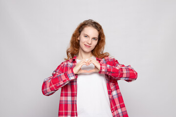 red-haired young girl in a plaid shirt on a white background with a place for text