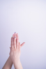 woman hands with nails painted with glossy nail polish and colored french on white background in vertical shot