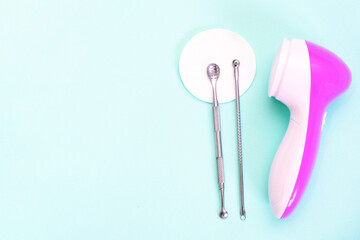 uno scoop and facial massager are on a soft turquoise background. flat lay, cosmetology