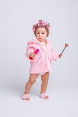 Cute little baby girl in pink terry with makeup isolated on a white background, repeats the...