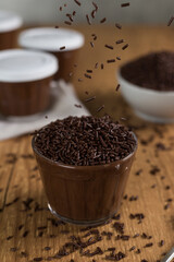 Brazillian chocolate sweet called Brigadeiro in pot on wooden desk background. Vegan version