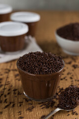 Brazillian chocolate sweet called Brigadeiro in pot on wooden desk background. Vegan version