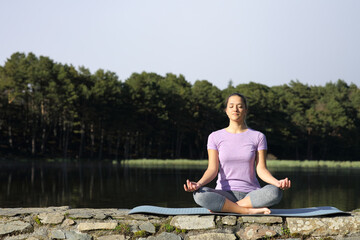 Fototapeta na wymiar Woman doing yoga lotus pose in the mountain