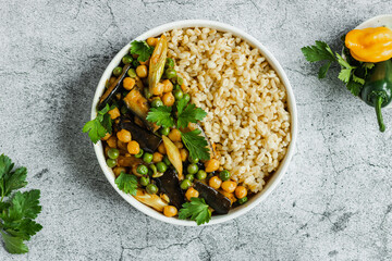 Eggplant chickpeas peas vegetarian vegan curry with bulgur in a pan on a gray background, top view. Indian cuisine. healthy food. vegan. plant base.