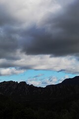 Montañas entre nubes y cielo azul