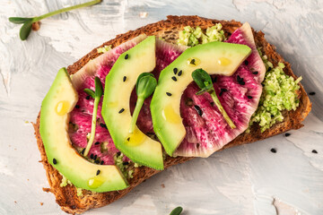 Avocado and watermelon radish toast with microgreen. Healthy green veggie breakfast sanddwich. banner, catering menu recipe place for text, top view