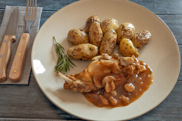 new potatoes with mushroom rabbit in a plate on a gray background