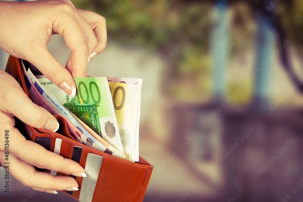 Wall mural Hand taking out money from pocket wallet. Counting money, economy concept, money distribution