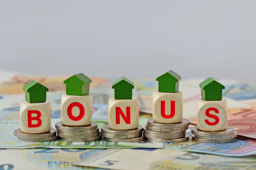 Wooden house and blocks with the word Bonus on coins and banknotes - Concept of home renovation...