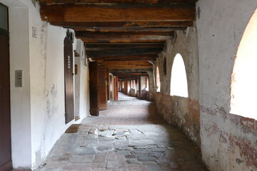 The ancient elevated covered “donkey road” in Brisighella built inside the buildings has ceiling with wooden beams and arched windows 