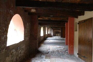 The ancient elevated covered “donkey road” in Brisighella built inside the buildings has ceiling with wooden beams and arched windows 