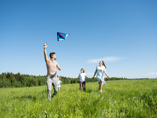 Family running through field with fly