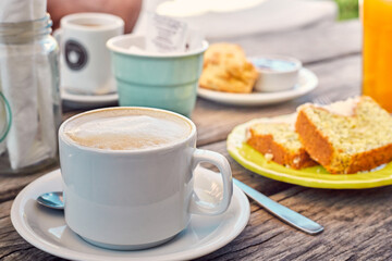 Close-up of cup of coffee with milk and a variety of breakfast selection