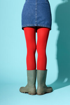 Anonymous woman in rubber boots and red tights