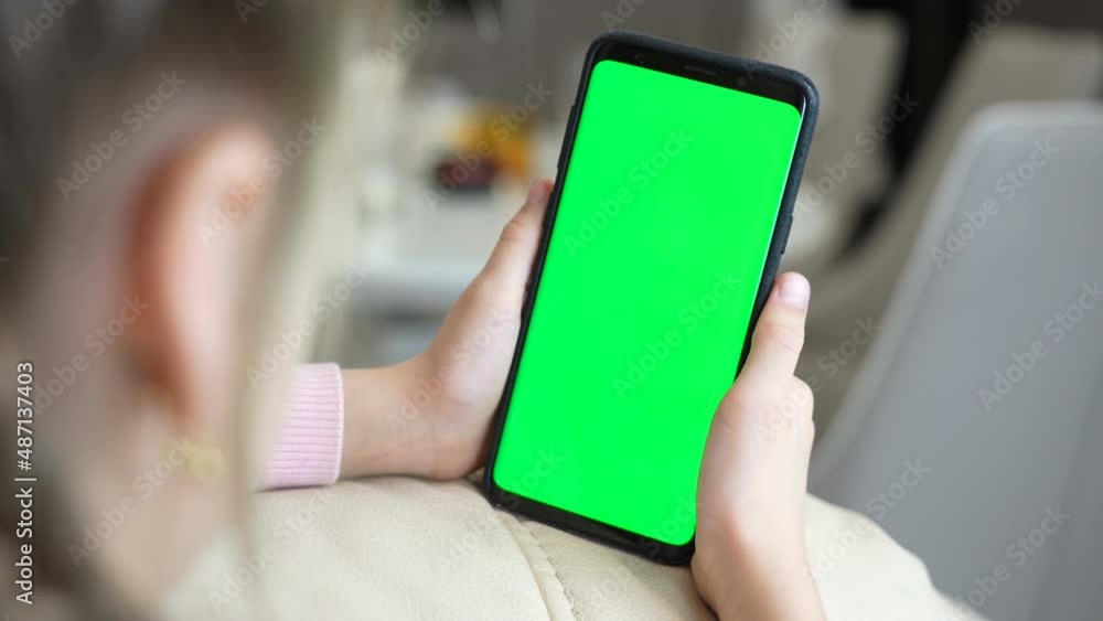 Poster little girl use smart phone with blank green screen mock up display for advertising text while rest 