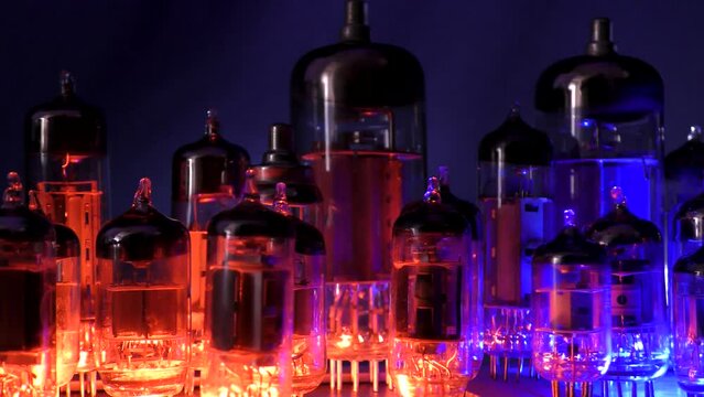 Vacuum TV and radio lamp.
Vacuum or radio tubes diodes, triodes, pentotes stand in red-blue light.