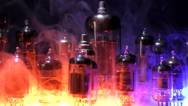 Vacuum TV and radio lamp in smoke.
Vacuum or radio tubes diodes, triodes, pentotes stand in red-blue smoke.
