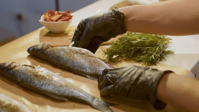 Fish on the table. Staffing raw fish with onions and tomatoes