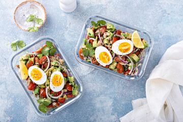 Meal prep containers with avocado tuna salad and boiled egg