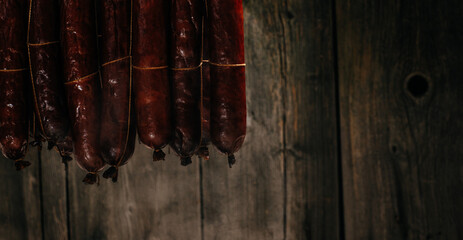 Process of smoking sausage hang in a cupboard with smoke. Clouds of smoke rise up and envelop the sausages hanging in a row, Long banner format