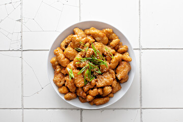 Orange chicken with green onions and sesame seeds