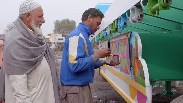 Master and student painter working on truck side, Pakistani Truck Art