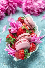 homemade pieces of sweet macaroni cookies on plate and peonies on the kitchen table. Summer celebration, wedding greeting card, invitation concept