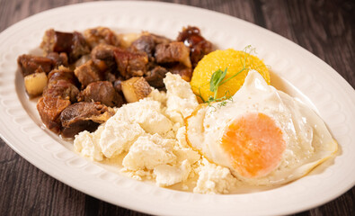 Traditional Romanian food called tochitura made of fried eggs, polenta and pork met. Delicious food photography.