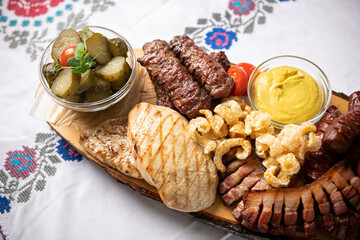 Traditional Romanian food. Close up view of a food plate made of pork meat against a wooden...