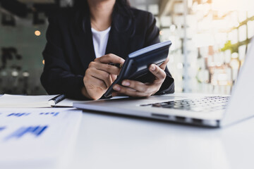 Close-up of a business woman using a calculator to calculate accounting and financial planning....