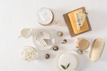 a set of fresh dairy products in various dishes on a white background. top view, flat lay. source of protein and vitamins.